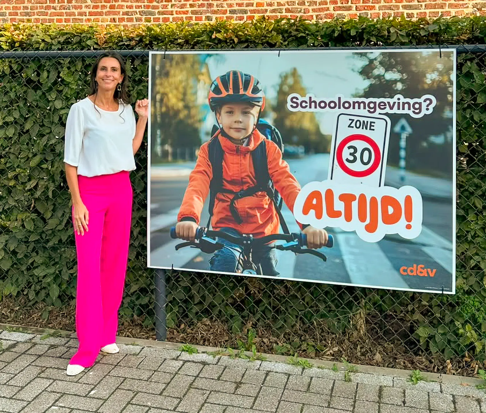 An Christiaens naast het campagnespandoek Zone 30